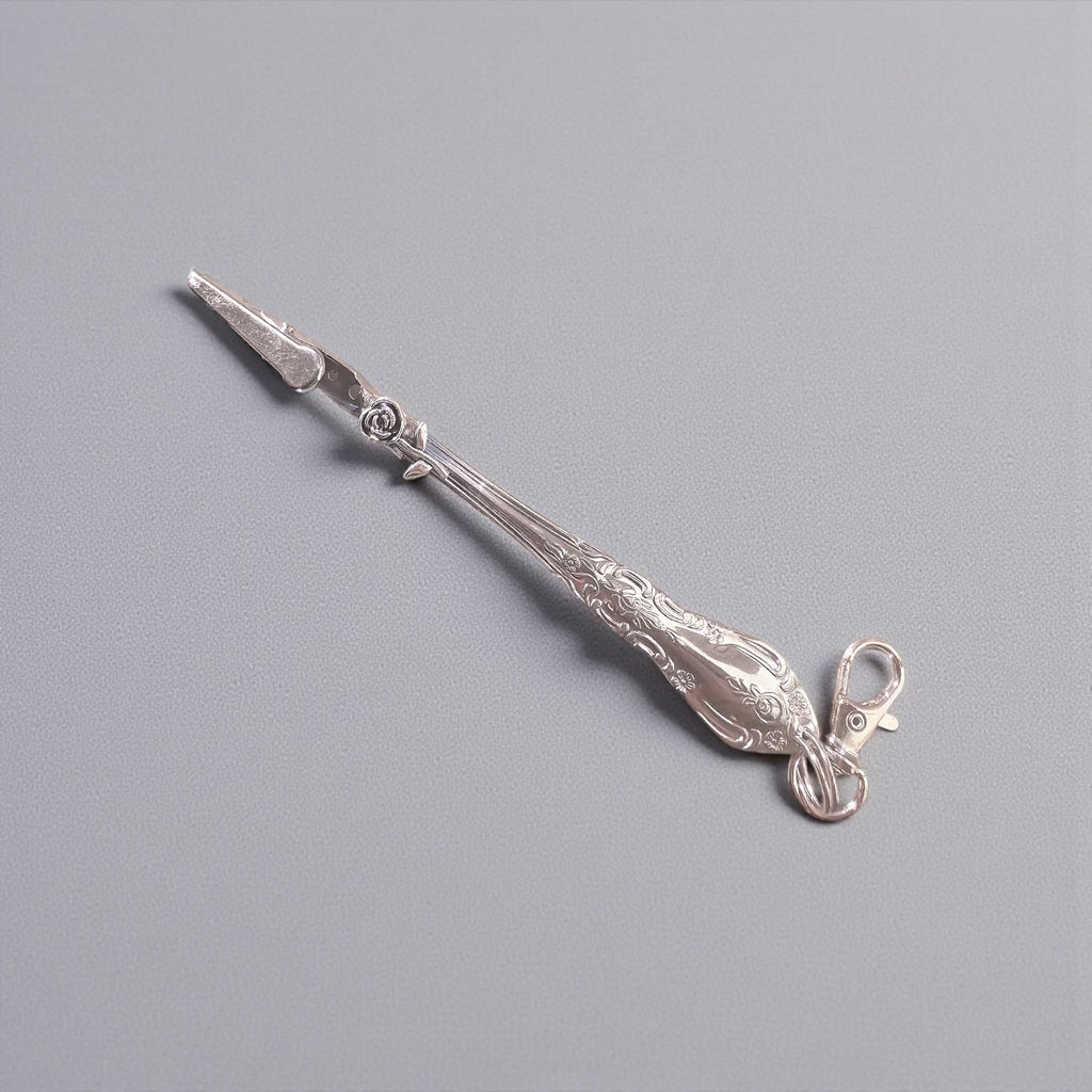 Decorative silver tool on a gray background