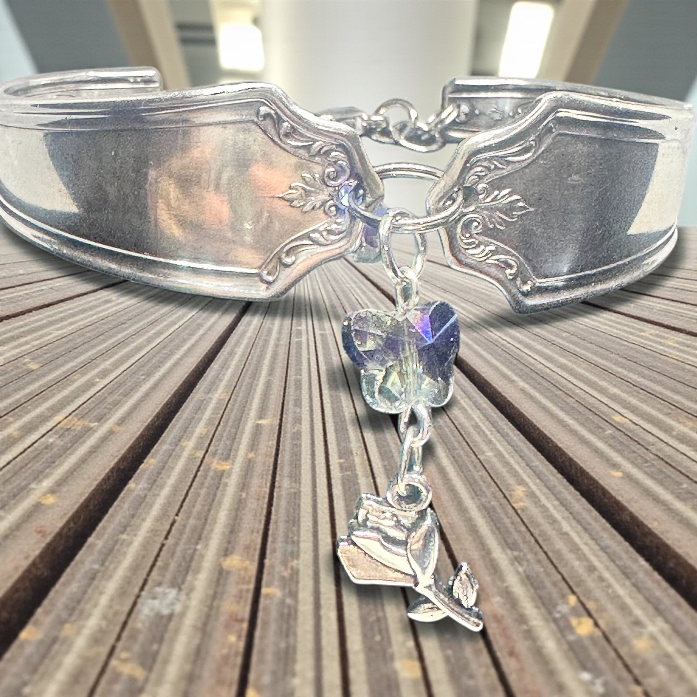 Silver bracelet with a butterfly charm on a wooden surface