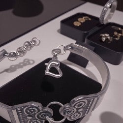 Silver bracelet with heart charm on a branded box
