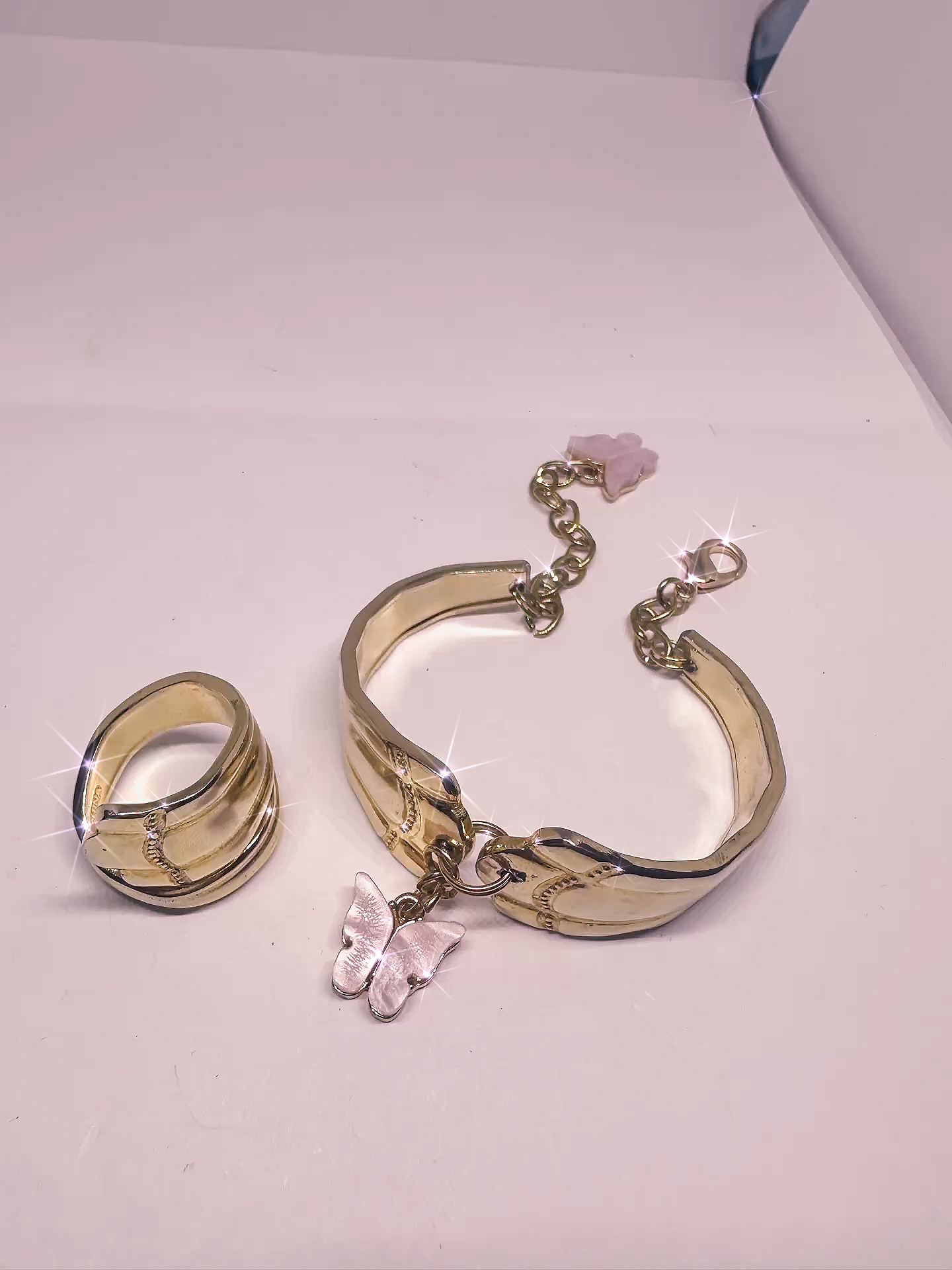 Gold Spoon Ring & Bracelet Set – Textured Design with Pink Butterfly Char displayed with sparkling highlights, showcasing the unique texture and charm of the vintage-inspired pieces.