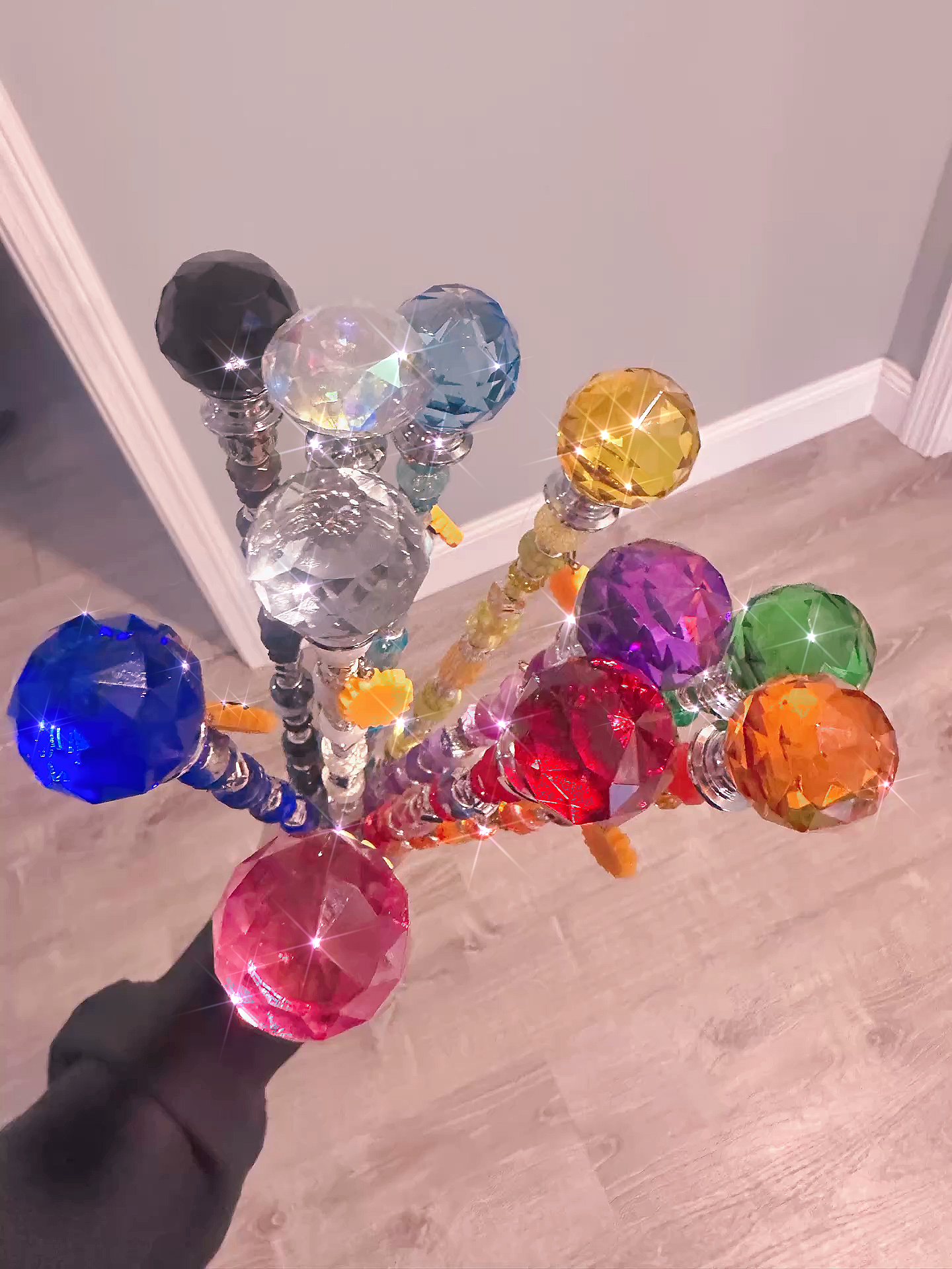 Sparkling Garden Fairy Wands held in a hand, emphasizing their colorful and whimsical charm for indoor gardening and plant décor.