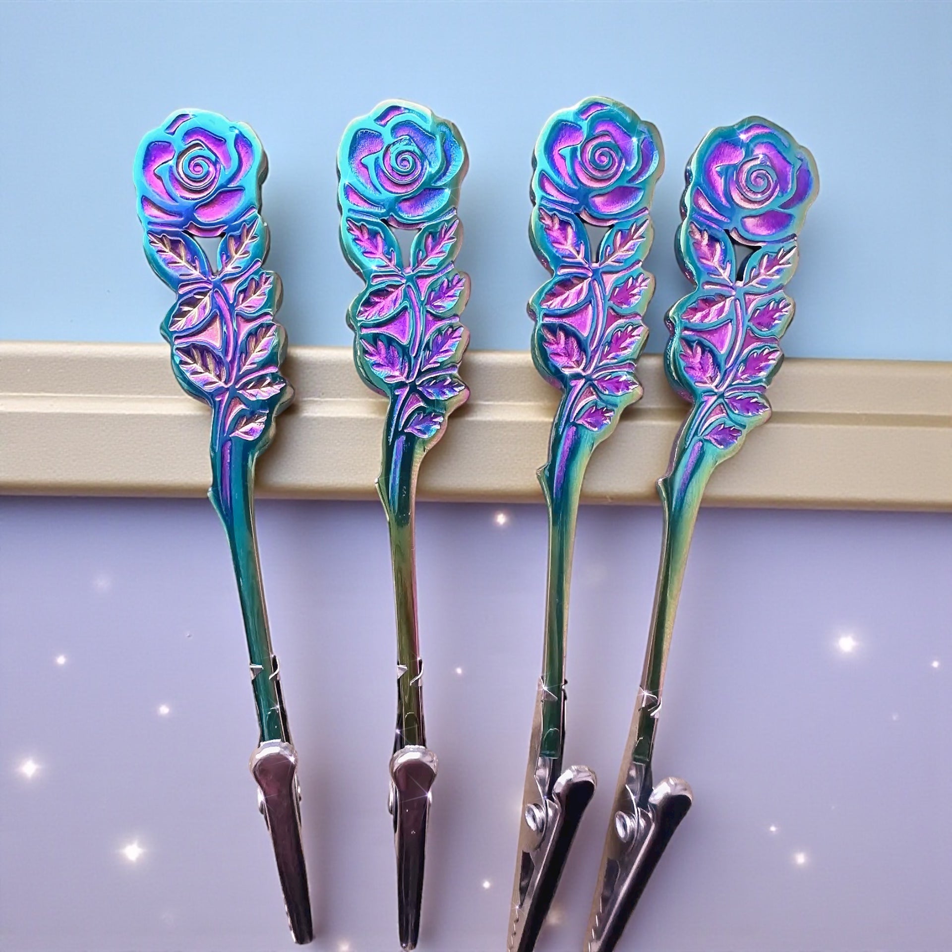 Four floral-patterned hair clips on a blue and purple gradient background