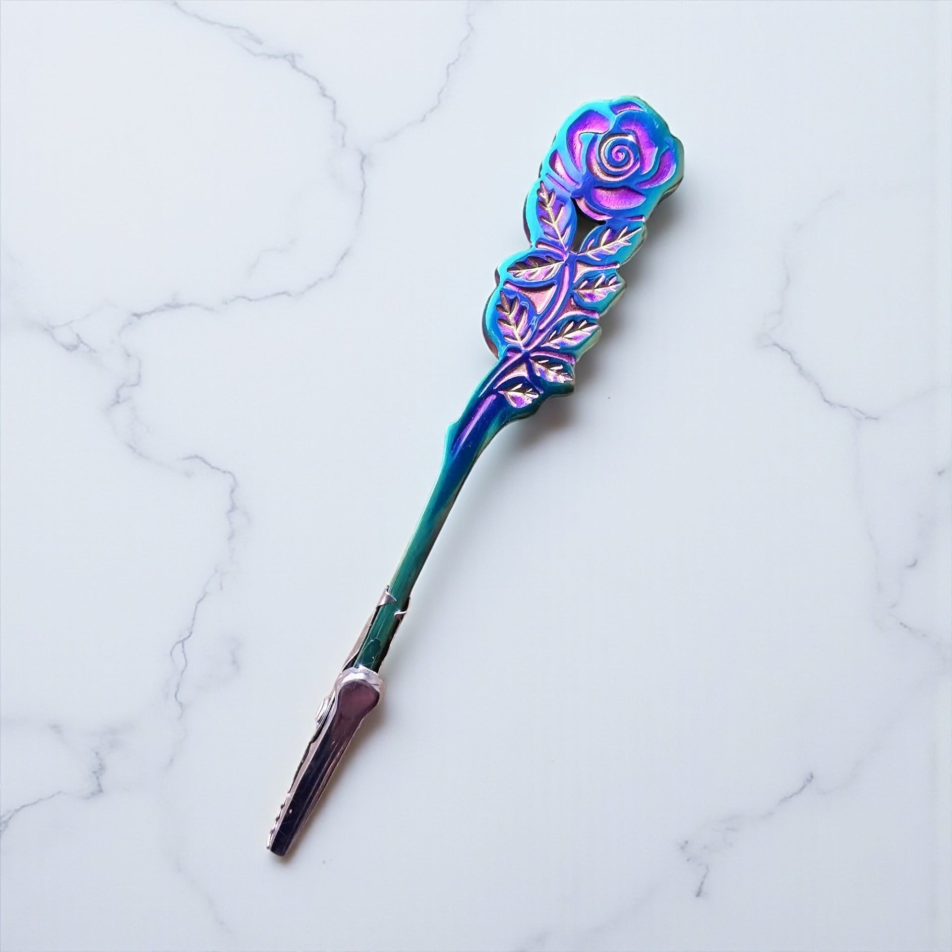 Decorative spoon with rose design on a marble surface