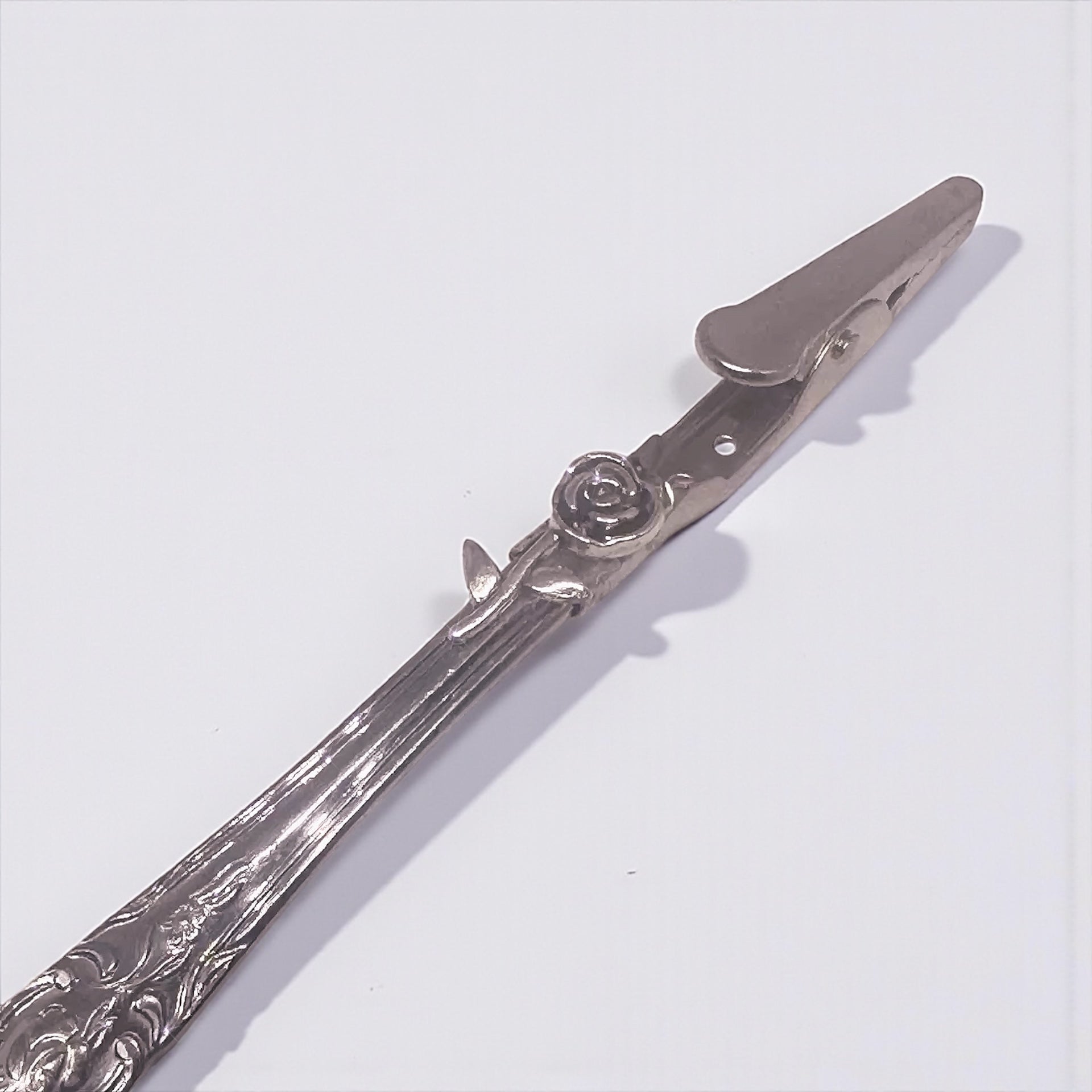Silver plier with decorative handle on a white background