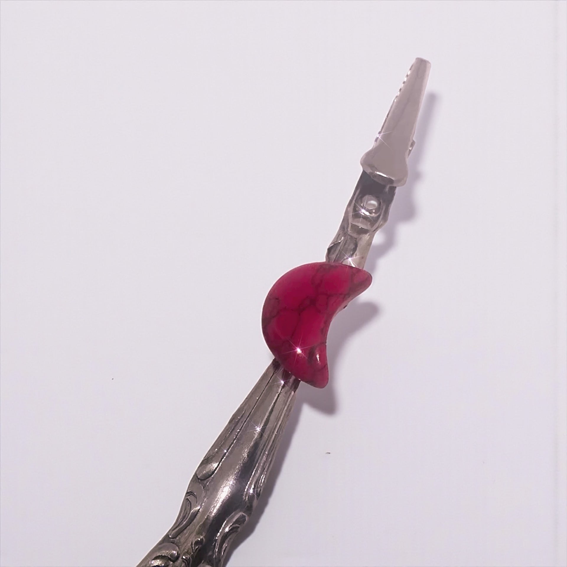 Silver tool with a red handle on a white background