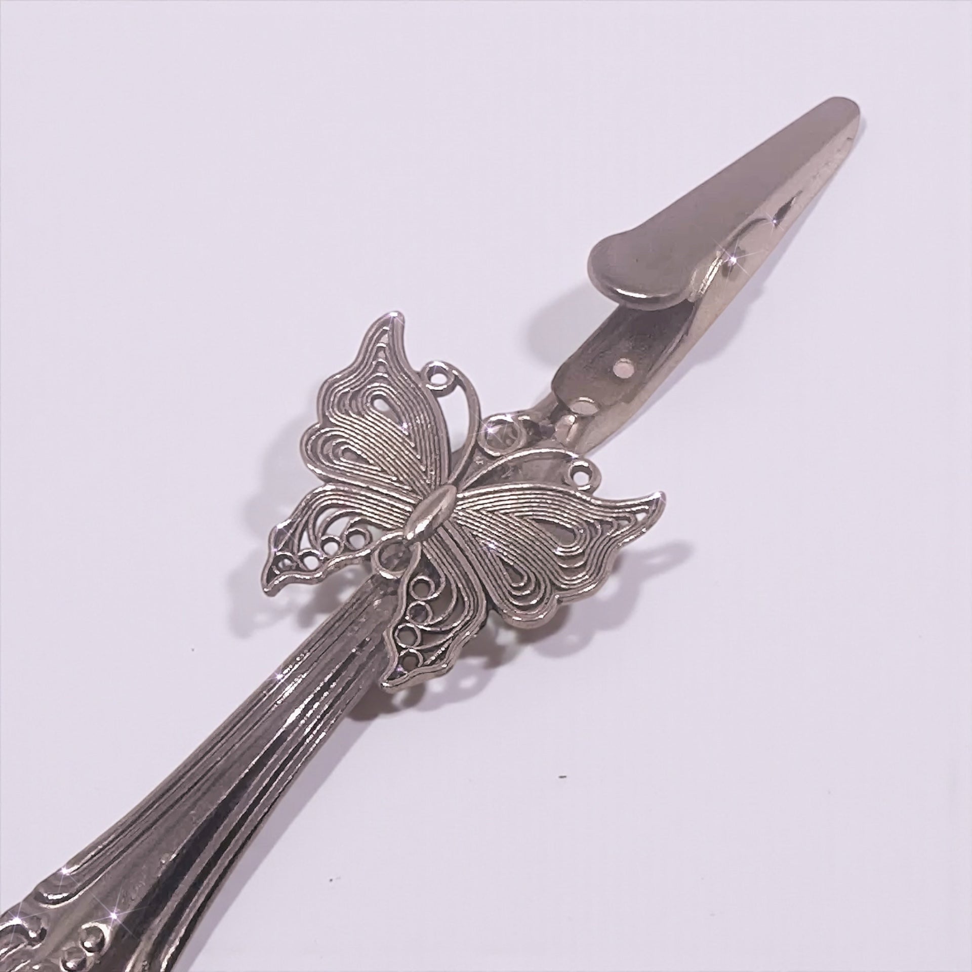 Silver butterfly-shaped hair clip on a white background