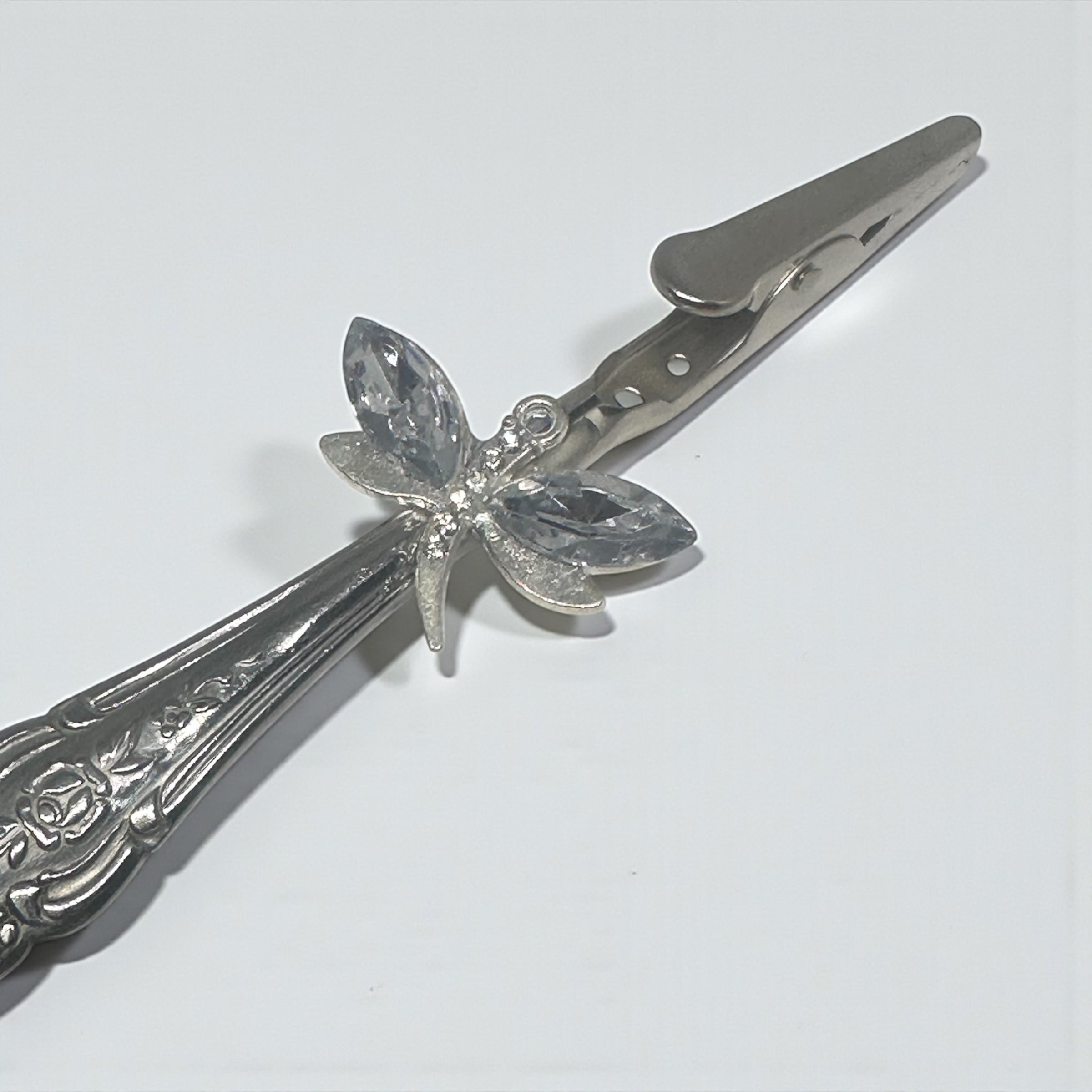 Butterfly-shaped hair clip with decorative elements on a white background