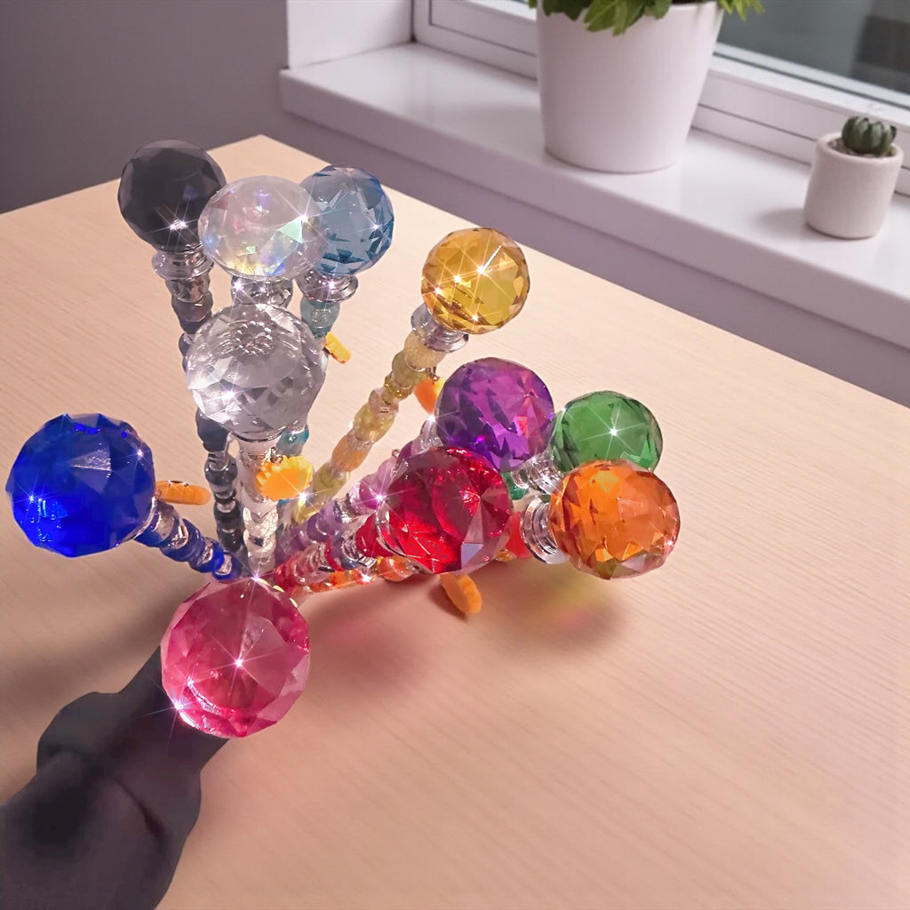 Brightly colored Garden Fairy Wands displayed on a wooden table, showcasing their unique bead arrangements and crystal tops. These handmade decorative plant stakes are perfect for any plant enthusiast.