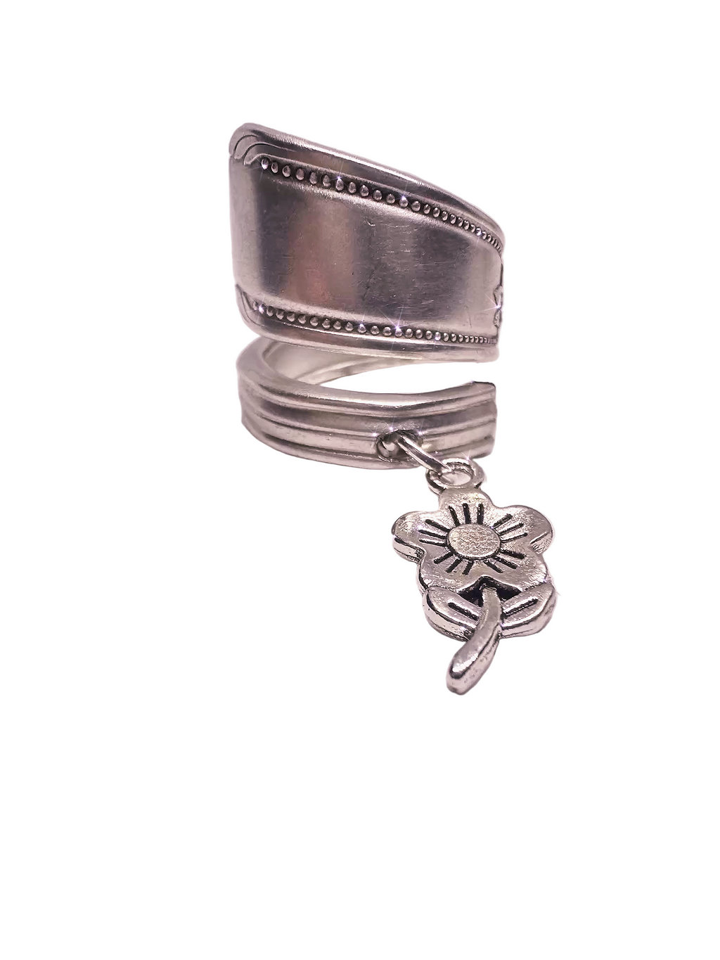 Set of silver rings with a flower charm on a white surface