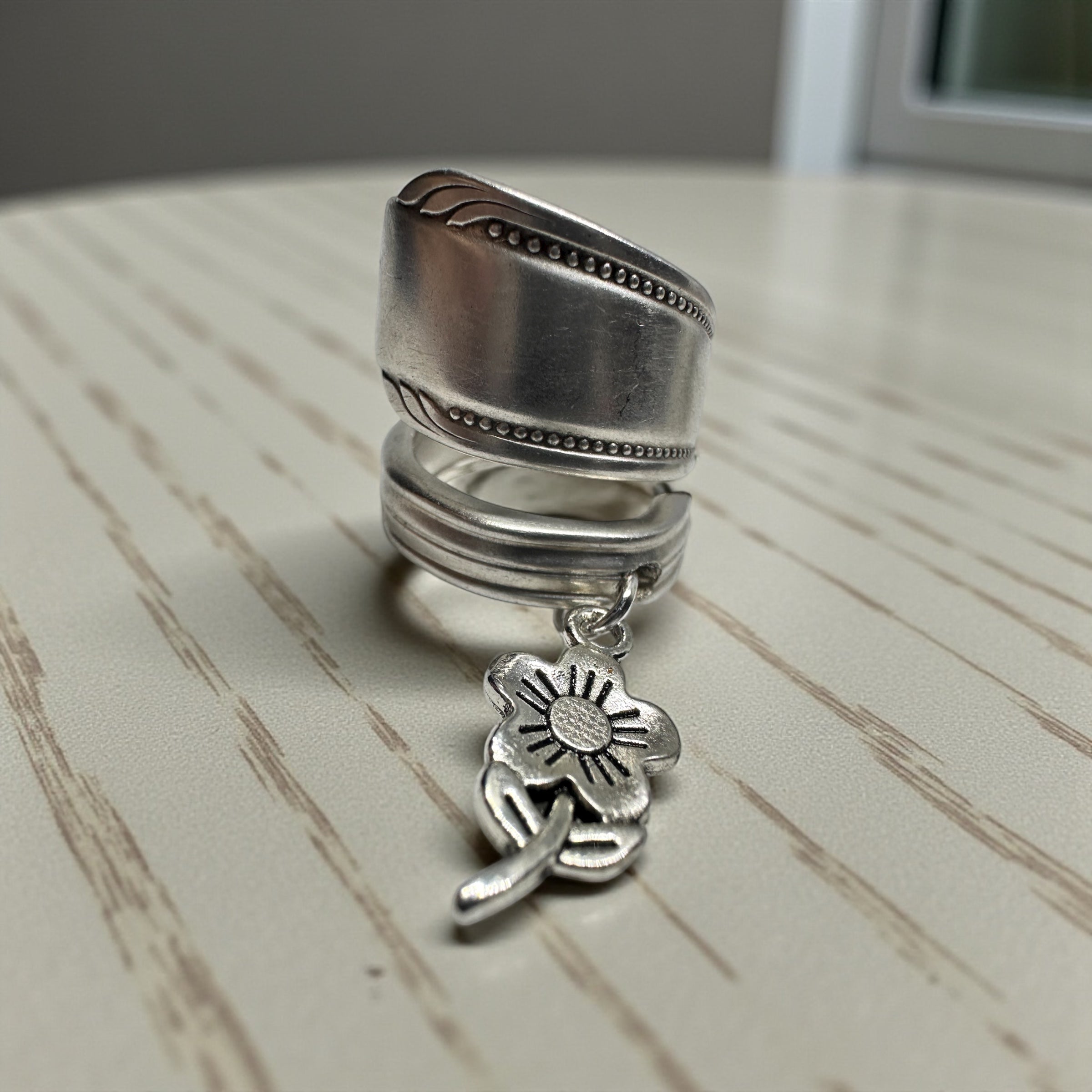 Silver ring with a pendant on a wooden surface