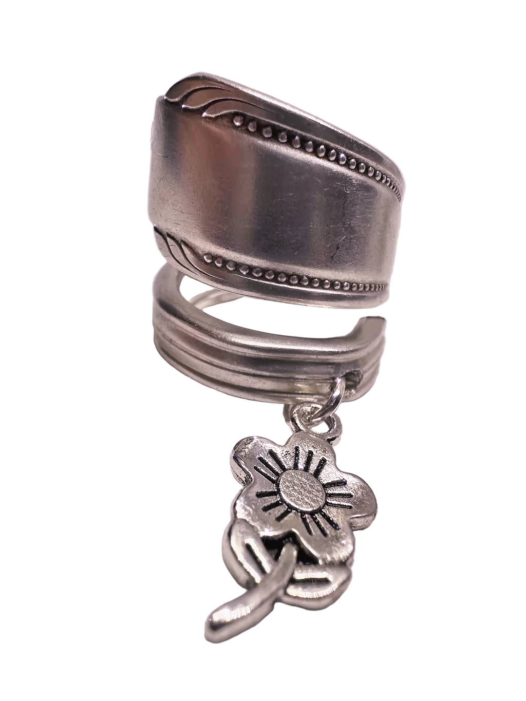 Silver spoon ring with a floral charm on a white background