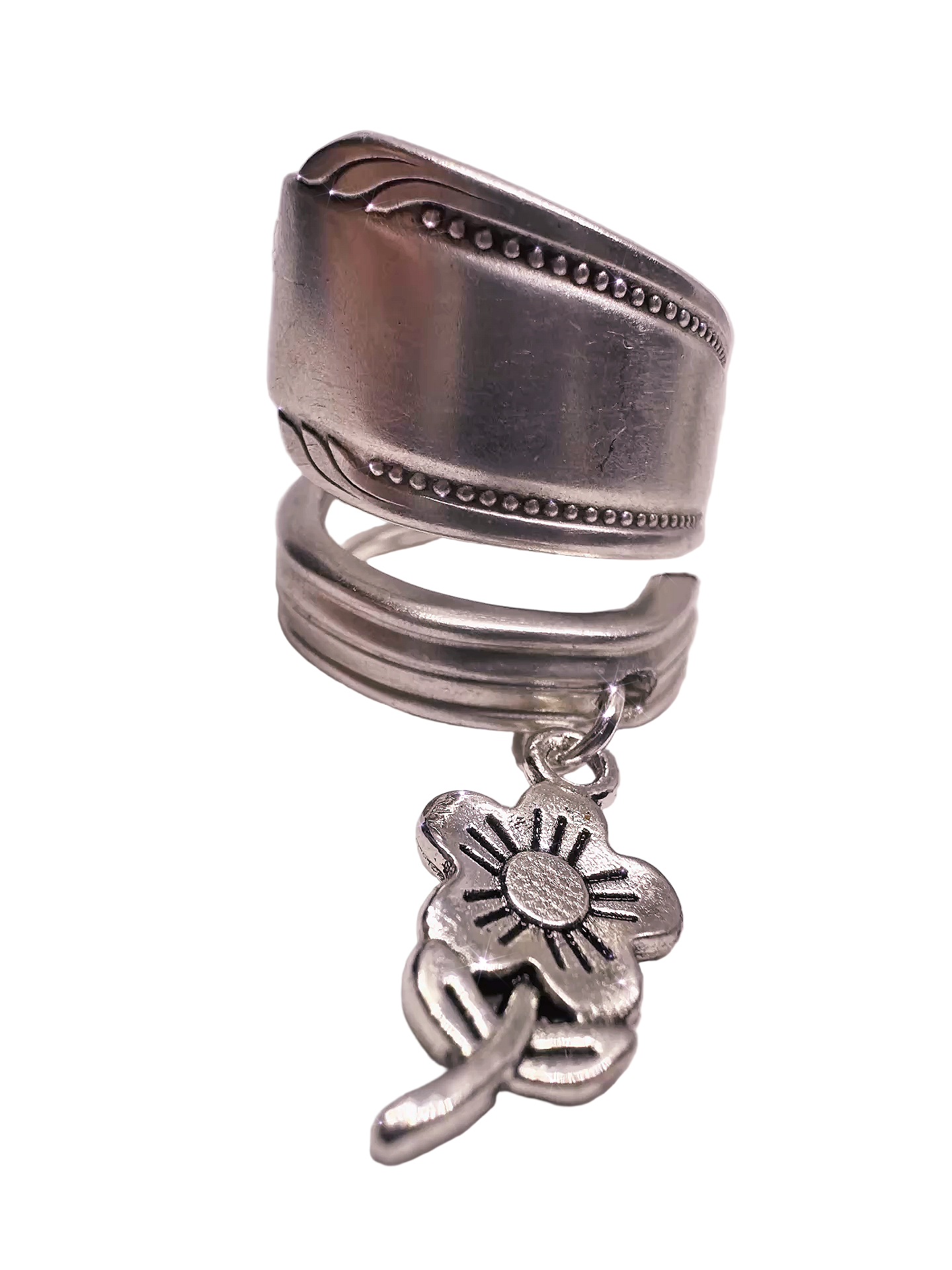 Silver spoon ring with a floral charm on a white background